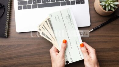 close up hands holding cash and check scaled