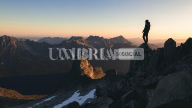 silhouette of a person standing on the top of a hill under the beautiful colorful sky in the morning scaled