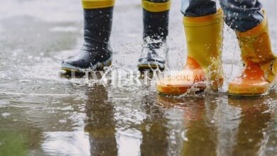 funny kids rain boots playing with paper ship by puddle scaled