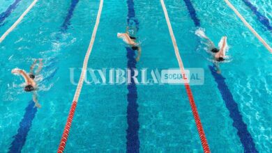 three male swimmers racing against each other scaled